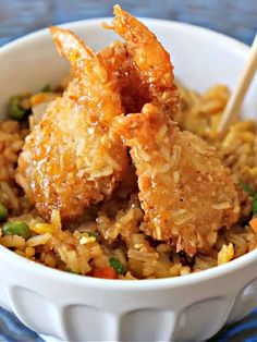 fried chicken and rice in a bowl with chopsticks sticking out of the top