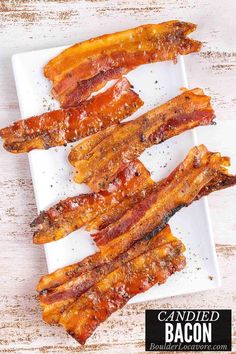 bacon strips on a white plate next to a small bowl of seasoning