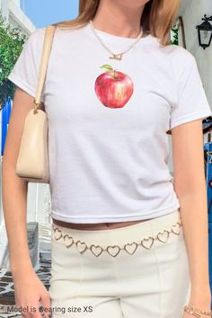 An apple a day keeps the doctor away 🍎 Get your fruity vitamins while wearing our trendy y2k baby tee shirt with a graphic red apple print. Style it with your low rise jeans or skirt and y2k sunglasses for the perfect vintage 2000s fit. Get yours now and wear it yourself or get a matching gift for your bestie in crime!  ------------------------------------------------------------------------------------------------------ Size guide Please take a moment to see the size chart, both in inches and Y2k Style Short Sleeve T-shirt With Fruit Print, Y2k Fruit Print Short Sleeve Tops, Y2k Style Fruit Print Short Sleeve Tops, Y2k Short Sleeve Top With Fruit Print, Summer Y2k T-shirt With Fruit Print, Y2k Short Sleeve T-shirt With Fruit Print, Fitted Short Sleeve T-shirt With Fruit Print, Y2k Cotton T-shirt With Fruit Print, Y2k Style Cotton T-shirt With Fruit Print