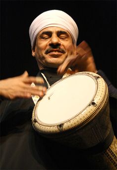 a man is holding a large drum in his hands