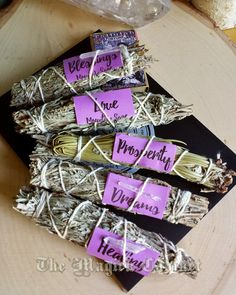 three bundles of white sage sitting on top of a wooden table