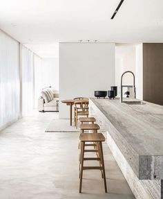 a long counter with stools in front of it next to a couch and coffee table