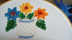 an embroidery project with flowers in a vase