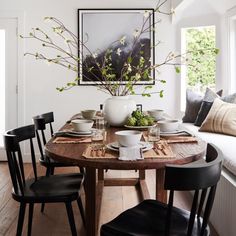 a dining room table with black chairs around it