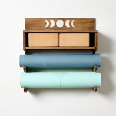 three yoga mats stacked on top of each other in front of a wall mounted shelf