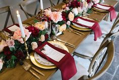 a long table set with place settings and flowers