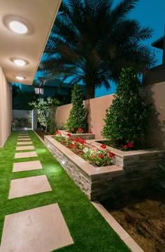 an outdoor garden with artificial grass and flowers in the planter boxes on either side