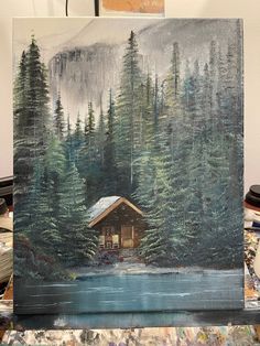 a painting of a cabin in the middle of a lake surrounded by trees and mountains