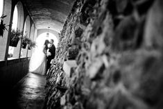 a bride and groom are standing in the tunnel