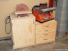 a table sawing on top of a wooden cabinet next to a power driller