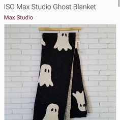 a black and white ghost blanket hanging on a brick wall