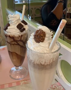 two glasses filled with ice cream and chocolate milkshakes