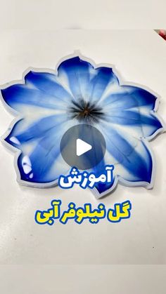 a blue flower with the words in arabic on it and an image of a person holding a