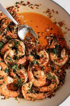 a bowl filled with shrimp and sauce on top of a table