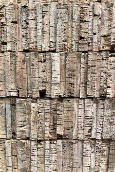 an old wooden wall with many pieces of wood stacked together