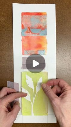 two hands are making an art project with colored paper and glue on top of a piece of paper