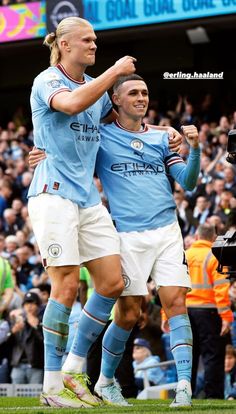 two soccer players are congratulating each other in front of an audience at a sporting event