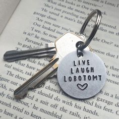 two keys are attached to a keychain that says live laugh lobotomt