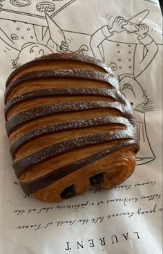 a piece of bread sitting on top of a paper towel covered in chocolate frosting