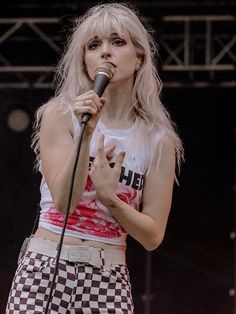 a woman with blonde hair holding a microphone