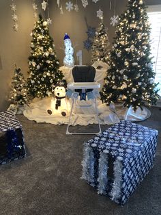 christmas trees and presents in a room decorated with snowflakes, lights and decorations