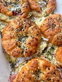 several pieces of bread that are covered in cheese and other toppings sitting on a white surface