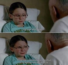 a woman in glasses sitting on top of a bed next to a man wearing glasses