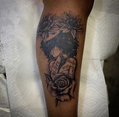 a woman's arm with tattoos and flowers on her left leg, in black and white