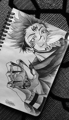 a drawing of an anime character is shown on a spiral notebook with black and white background