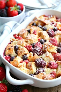 a casserole dish with berries and powdered sugar