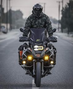 a man riding on the back of a motorcycle down a street