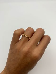 a person's hand with a gold ring on it