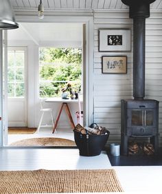 a living room with a wood stove and pictures on the wall next to an open door