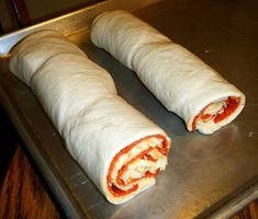 two burritos sitting on top of a metal tray