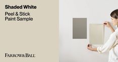 a woman is painting a wall with white paint and she has her hands on the panel