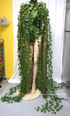 a mannequin is covered in green ivy