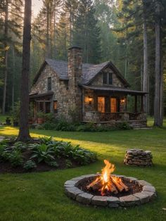 a fire pit sitting in the middle of a lush green field next to a house