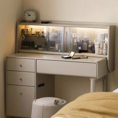 a desk with a cell phone on top of it next to a mirror and drawers