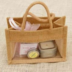 a small bag with some items inside it on a tablecloth covered surface, in the shape of a shopping bag