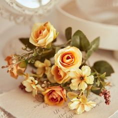 some yellow flowers are sitting on top of a white plate with a mirror in the background