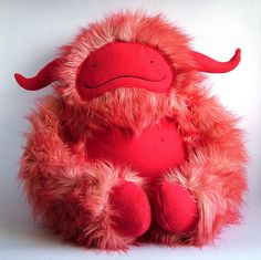 a red stuffed animal sitting on top of a white table