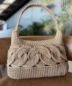 a handbag sitting on top of a brown chair