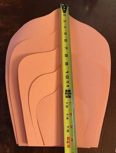 there are several pieces of pink paper with a measuring tape on top of each one