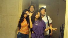 a group of young people standing next to each other in front of a bathroom mirror