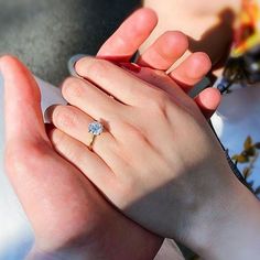 two people holding hands with a diamond ring