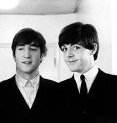 two young men in suits and ties standing next to each other with their eyes closed