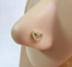 a close up view of a nose with a heart shaped diamond ring on it's side