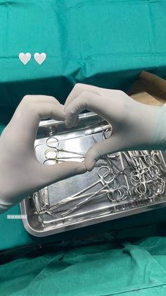 a gloved hand in white gloves holding a silver tray with scissors and writing on it