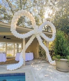 an outdoor event with white balloons and table cloths in the shape of a bow