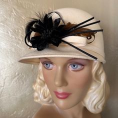 This Stunning 1960's Fashion Statement Consists Of A Rounded Crown Made Of Winter White Felt. There Is A Short Brim At The Front, And A Narrow Band Around The Crown Which Ends In A Bow At The Front. There Is A Beautiful Black Fabric "Flower" And Several Black "Stems" Attached At The Front, And Two Brown Curly Feathers. The Hat Wearing Requirement From Previous Decades Was Drastically Subsiding In The 1960s. Most Dressy Hats In The 1960s Were Worn By Women Who Embraced The Traditional Etiquette R Straw Flowers, Etiquette Rules, Dressy Hats, 1960's Fashion, Feather Trim, Vintage Hats, 1960s Fashion, Fabric Flower, Trim Color